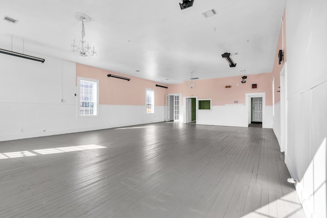 empty room with an inviting chandelier and wood-type flooring