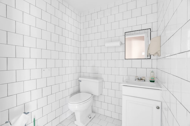 bathroom featuring toilet, tile walls, and vanity