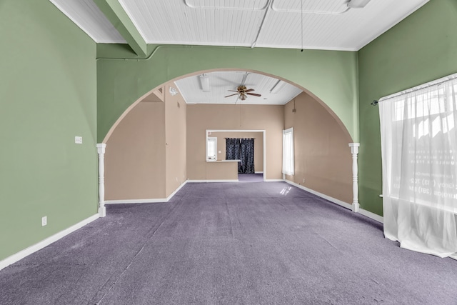 unfurnished living room with ceiling fan, carpet flooring, and a high ceiling