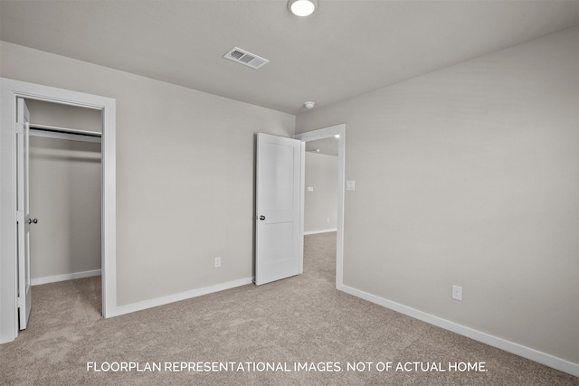 unfurnished bedroom featuring a closet, light colored carpet, and a walk in closet