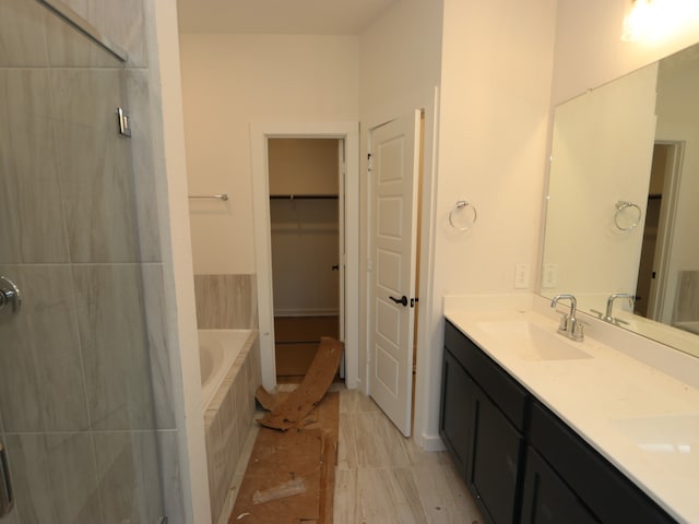 22435 Birchfield Grove Ln, New Caney, TX 77357 - full bathroom featuring double vanity, a bath, a tile shower, and a walk in closet