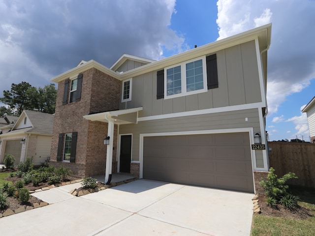 22435 Birchfield Grove Ln, New Caney, TX 77357 - view of front of property featuring board and batten siding, an attached garage, driveway, and brick siding