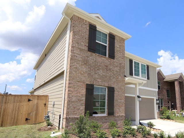 22435 Birchfield Grove Ln, New Caney, TX 77357 - view of front of house featuring an attached garage, brick siding, driveway, and board and batten siding