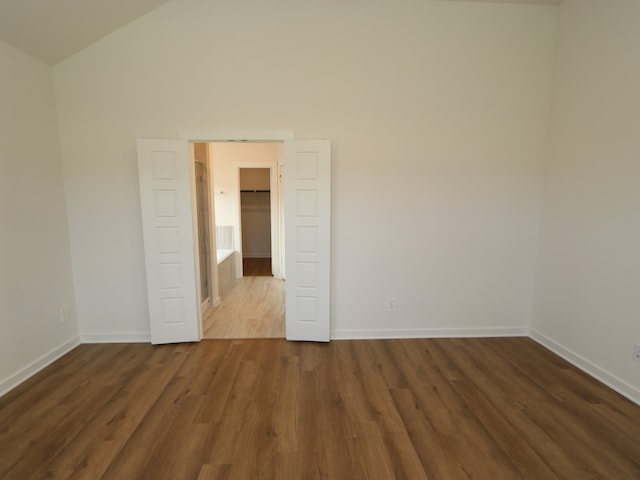 22435 Birchfield Grove Ln, New Caney, TX 77357 - empty room featuring dark wood finished floors and vaulted ceiling