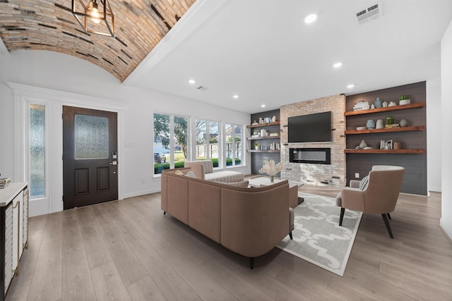 living room with light wood-style floors, a fireplace, built in features, and recessed lighting