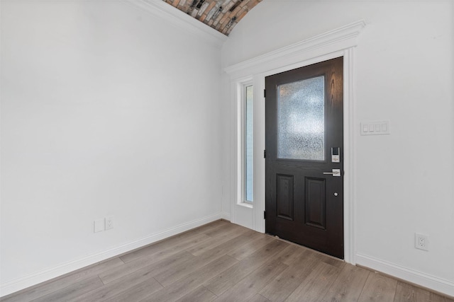 entryway with light wood-style floors, lofted ceiling, and baseboards