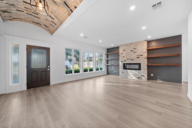 unfurnished living room with light wood-type flooring, a fireplace, visible vents, and recessed lighting