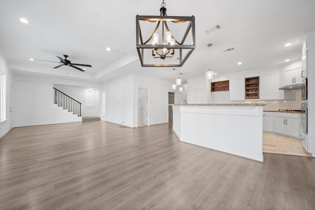 kitchen featuring open floor plan, visible vents, decorative light fixtures, and white cabinets