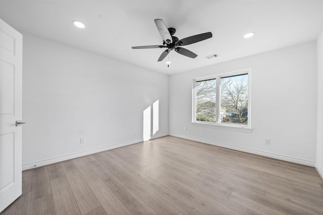 empty room with light wood-type flooring, baseboards, and recessed lighting