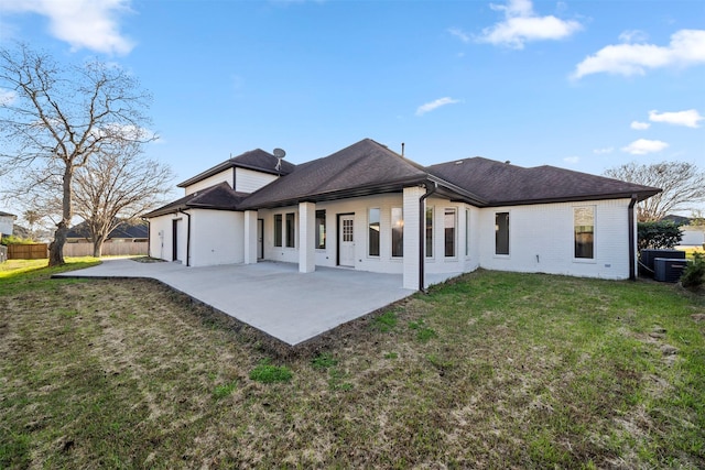 rear view of property featuring a patio, a yard, fence, and brick siding