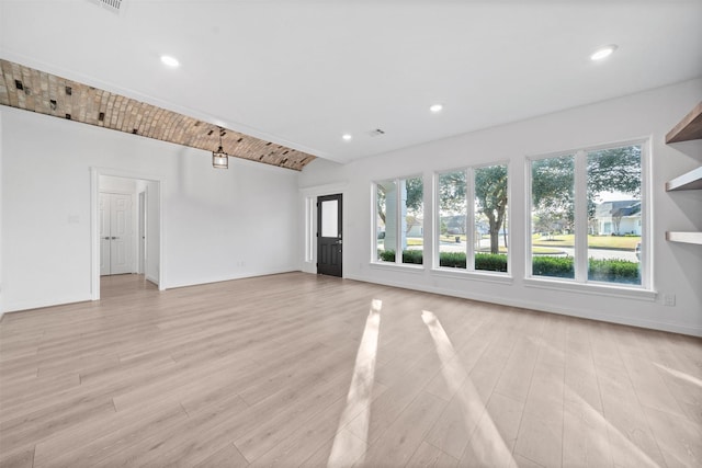 unfurnished living room with lofted ceiling, recessed lighting, light wood-style flooring, and baseboards