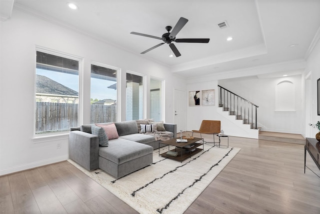 living room with a mountain view, visible vents, stairway, light wood finished floors, and crown molding