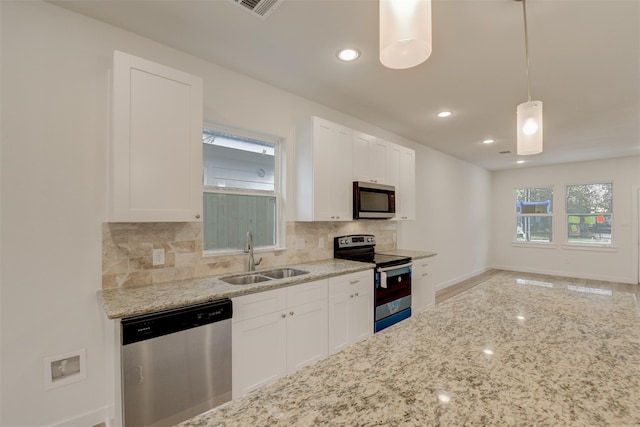 kitchen with white cabinetry, sink, appliances with stainless steel finishes, decorative backsplash, and pendant lighting