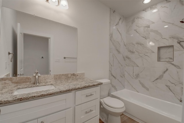 full bathroom with tiled shower / bath combo, vanity, and toilet