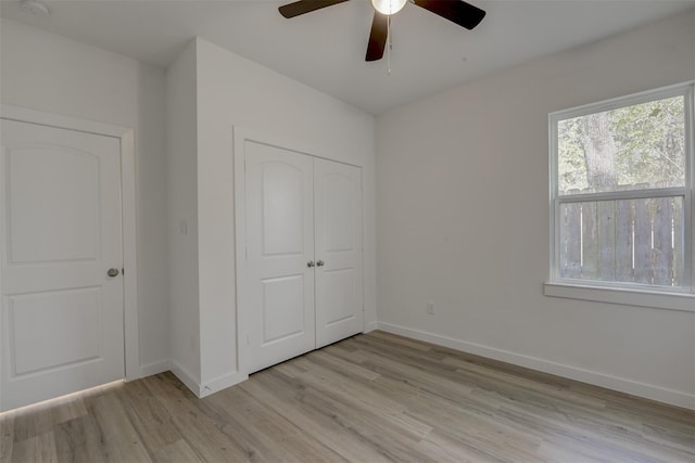 unfurnished bedroom with light hardwood / wood-style flooring, ceiling fan, and a closet