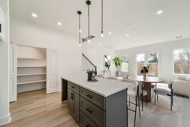 4430 Edmund St, Houston, TX 77020 - kitchen with open floor plan, light wood finished floors, a center island, light countertops, and decorative light fixtures