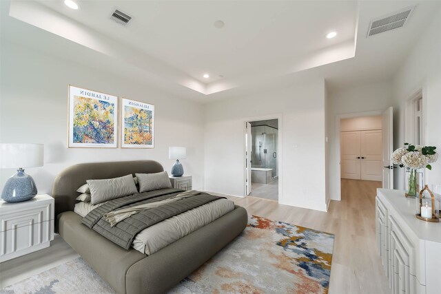bedroom with recessed lighting, visible vents, light wood-style flooring, and a raised ceiling