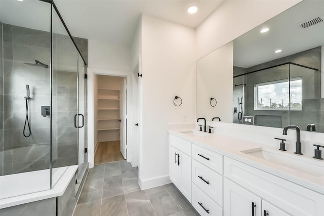 4430 Edmund St, Houston, TX 77020 - full bathroom featuring a shower stall, double vanity, a walk in closet, recessed lighting, and baseboards