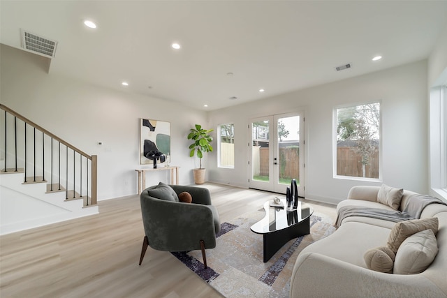 4430 Edmund St, Houston, TX 77020 - living area featuring light wood finished floors, plenty of natural light, recessed lighting, stairs, and french doors