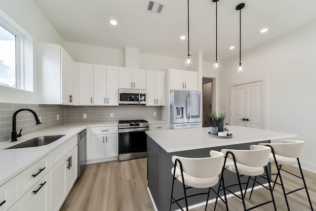 4430 Edmund St, Houston, TX 77020 - kitchen with appliances with stainless steel finishes, a sink, a kitchen island, a breakfast bar, and decorative backsplash