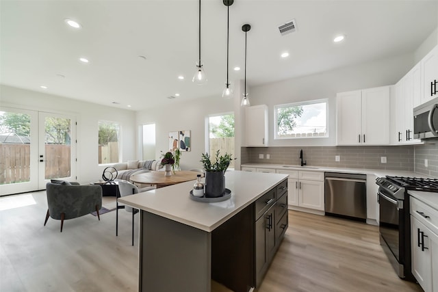 kitchen with a sink, appliances with stainless steel finishes, light countertops, and a healthy amount of sunlight