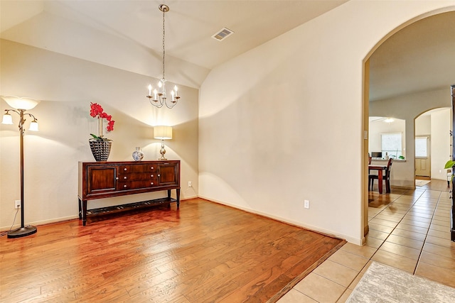 interior space featuring vaulted ceiling, a notable chandelier, and light hardwood / wood-style floors