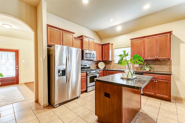 kitchen featuring backsplash, a kitchen island, stainless steel appliances, and light tile patterned floors