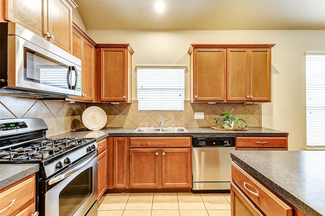 kitchen featuring appliances with stainless steel finishes, sink, plenty of natural light, and light tile patterned floors