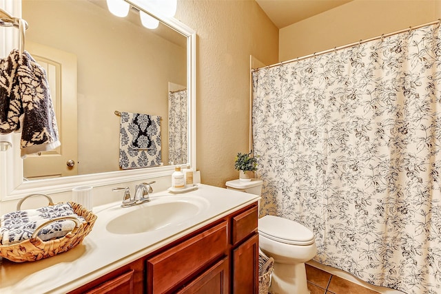 bathroom with toilet, tile patterned flooring, and vanity