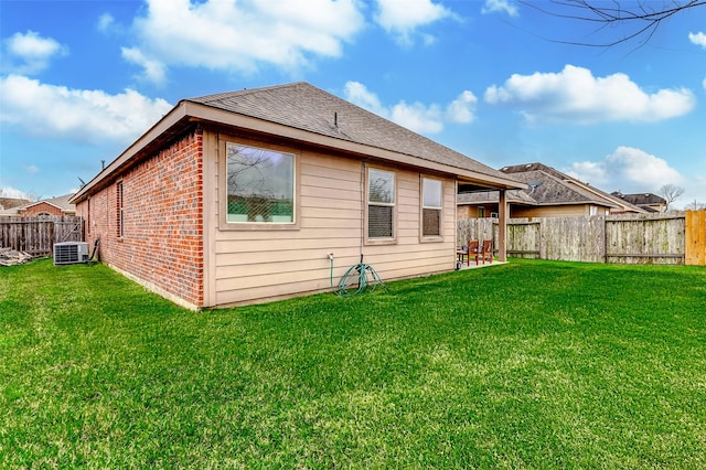 back of property featuring a lawn and central AC