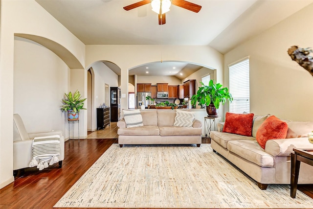 living room featuring hardwood / wood-style flooring, ceiling fan, and vaulted ceiling