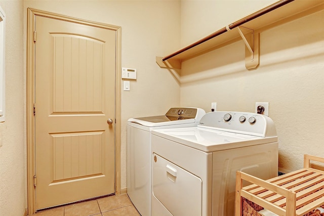 laundry room with washing machine and dryer and light tile patterned floors