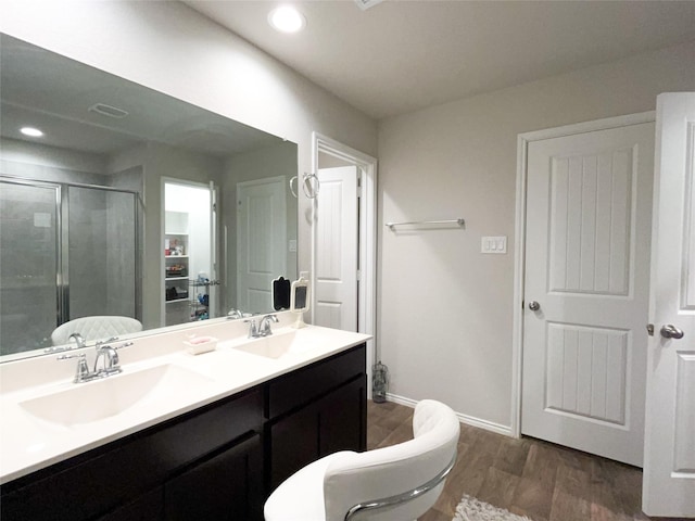 bathroom with wood-type flooring, vanity, and walk in shower