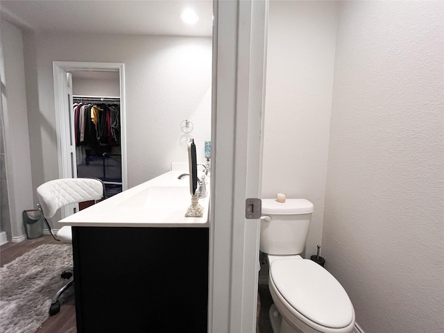 bathroom with hardwood / wood-style flooring, vanity, and toilet