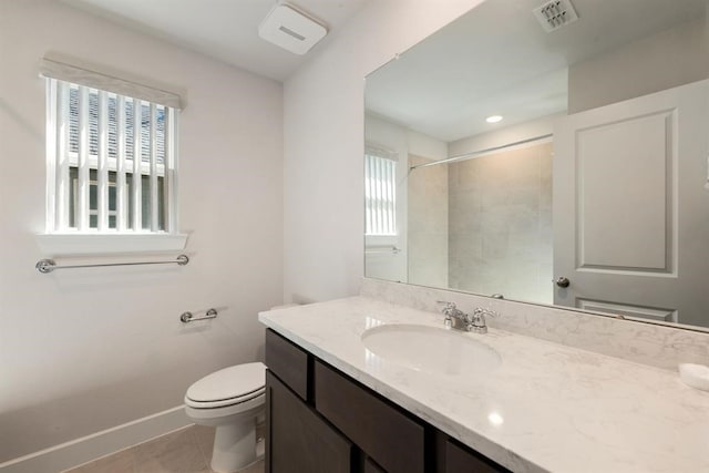 bathroom featuring toilet, vanity, tile patterned flooring, and tiled shower