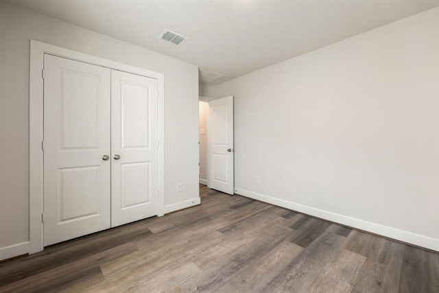 unfurnished bedroom with a closet and wood-type flooring