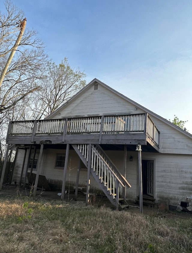 back of property featuring stairs and a wooden deck