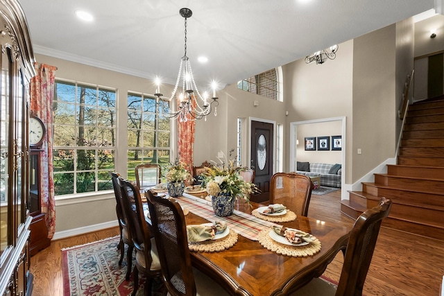 dining space featuring ornamental molding, hardwood / wood-style flooring, and a notable chandelier