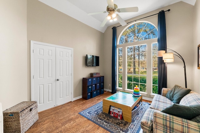 living room with light wood-type flooring, high vaulted ceiling, and ceiling fan