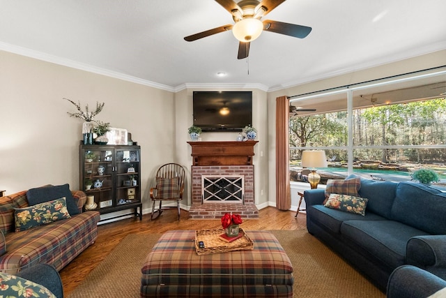 living room featuring a fireplace, hardwood / wood-style floors, crown molding, and ceiling fan