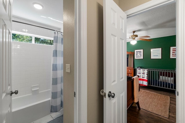 bathroom with ceiling fan, shower / bathtub combination with curtain, and hardwood / wood-style floors