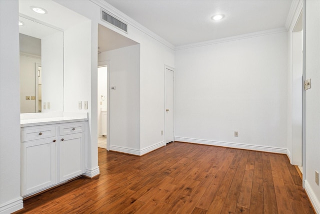 unfurnished bedroom with crown molding and dark hardwood / wood-style flooring