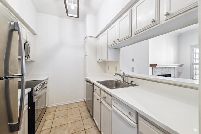 kitchen featuring light tile patterned floors, sink, stainless steel appliances, and white cabinets