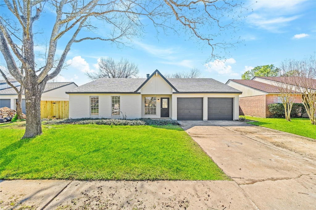 view of front of house featuring an attached garage, driveway, fence, and a front yard