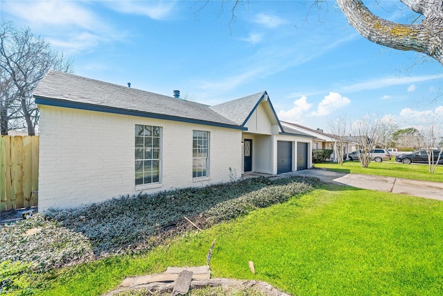 view of front of property featuring driveway, an attached garage, fence, a front lawn, and brick siding