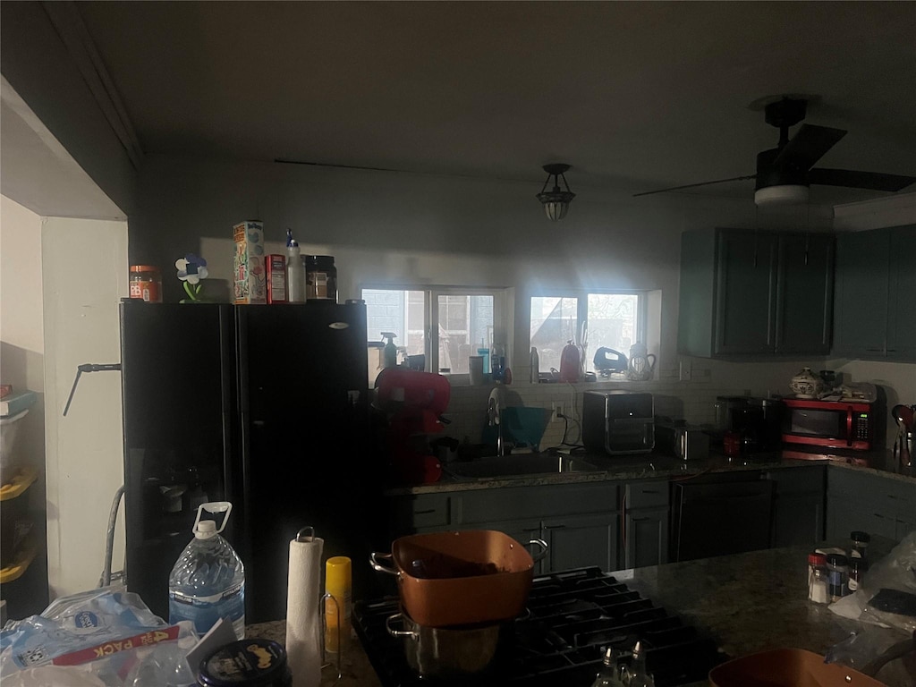 kitchen featuring sink, ceiling fan, and black fridge