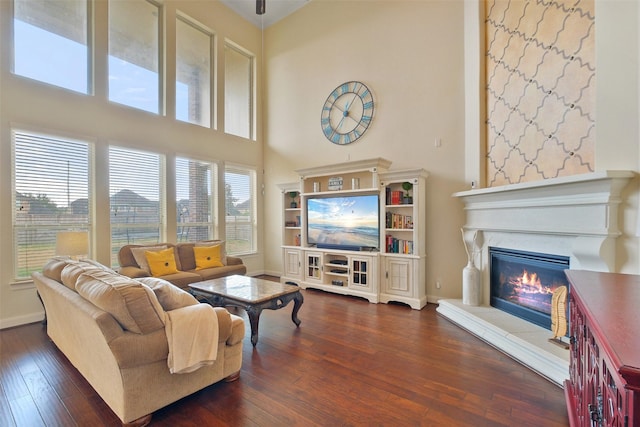 living room with dark hardwood / wood-style flooring and a high ceiling