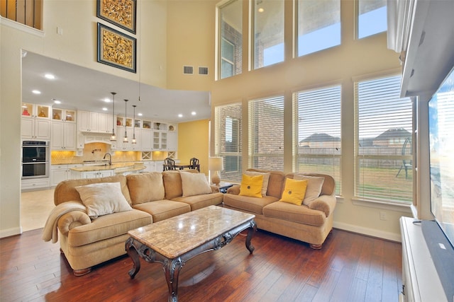 living room featuring a high ceiling and dark hardwood / wood-style floors