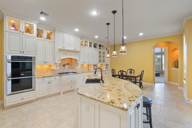 kitchen with sink, stainless steel appliances, white cabinets, and light stone counters