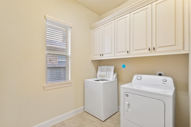 laundry room featuring cabinets, light tile patterned floors, and separate washer and dryer